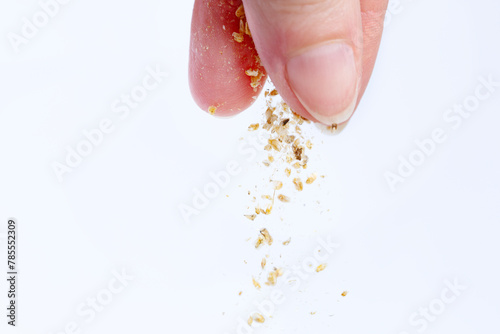 A woman's hand pours dry food for aquarium fish. Macro photography. Isolate