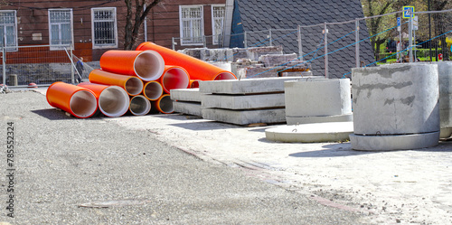 Materials for the repair of water pipes were collected on the square. Plastic large orange pipes, concrete circles and cobblestones and temporary blocks to restrict traffic. repair.