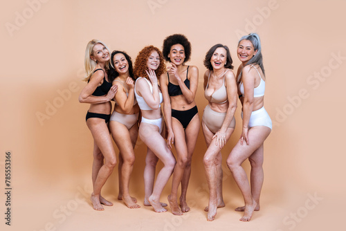 Beauty image of a group of women with different age and body posing in studio for a body positive photoshooting. Mixed female models in lingerie on colored backgrounds.