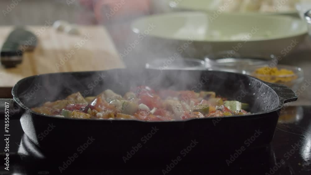 Close-up of steamed vegetables - tomatoes and zucchini - sprinkled with dried cumin by a skilled chef in a restaurant. Close up. Slow motion. Close-up of steamed vegetables - tomatoes and zucchini - sprinkled with dried cumin by a skilled chef in a restaurant. Close up. Slow motion.