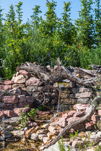 Foto Natural garden with stones, old wood and watercourse