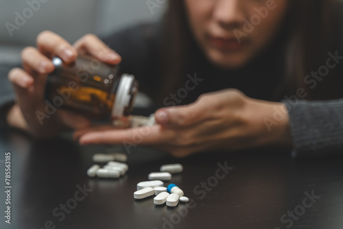 Anti drug, drug addict asian young woman, girl hand reaching for syringe, medicament with narcotic on table at home, abuse overdose. Sick pain of health, unhealthy people. Suicide depressed or despair photo