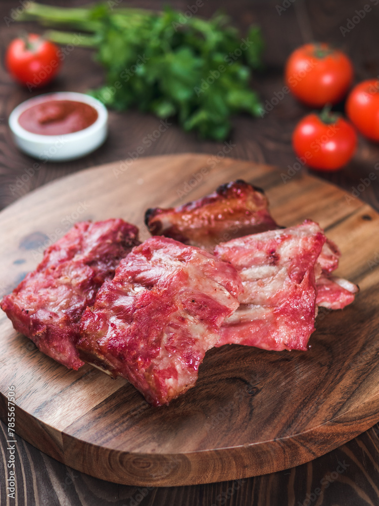 pork ribs on wooden plate, vertical, copy space