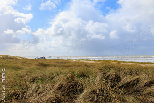  Dunes and the stormy sea with wild waves in the Dutch town of Bergen aan Zee on a stormy day with a cloudy sky