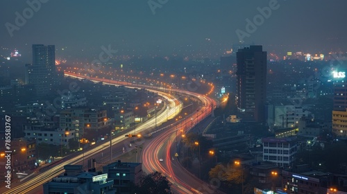 City Highway at Night. Traffic streams along a bustling highway against the backdrop of a city ablaze with lights, encapsulating the vibrancy of urban living.