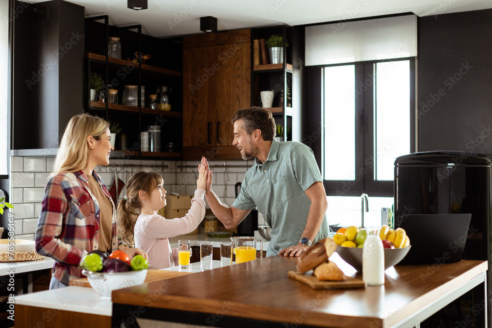 Family chatting and preparing food around a bustling kitchen counter filled with fresh ingredients and cooking utensils Family chatting and preparing food around a bustling kitchen counter filled with fresh ingredients and cooking utensils