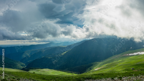 Sun shining through stormy clouds above Parang mountains. A dramatic sky can be seen as sun rays are penetrating the rainy clouds. Carpathian Massif  Romania. 