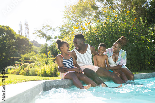 African American family enjoying time by pool at home, young boy laughing photo