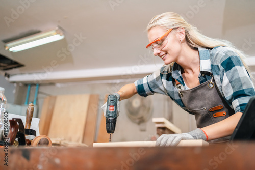 In the carpenter's shop, a professional woman crafts wooden furniture, using tools with skill in her woodwork occupation, showcasing industry prowess.