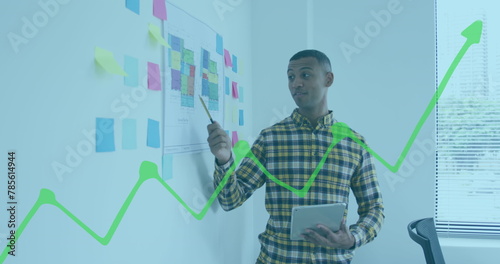 Image of financial graphs and data over biracial man working in office