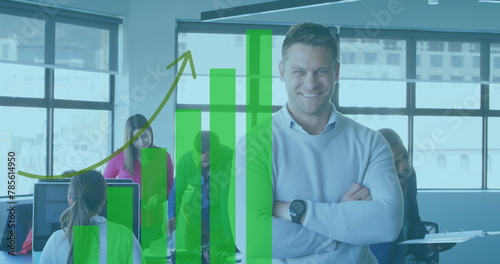 Image of financial graphs and data over happy caucasian man looking at camera in office