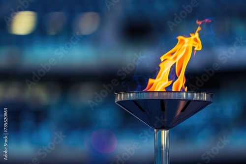 The Olympic flame ablaze against a sports stadium backdrop