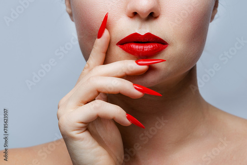 Closeup of Woman's Face with Red Stiletto Nails and Matching Lipstick