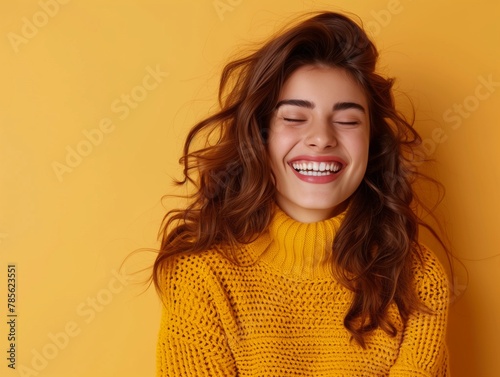 Portrait of happy young woman smiling at camera isolated on bright yellow background