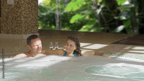 Man and woman relaxing in the hot tub on their exotic honeymoon photo