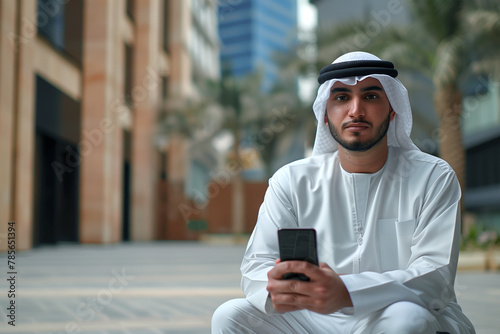 Man Sitting on Ground Holding Cell Phone