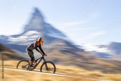 Speedy mountain biking adventure with scenic backdrop photo