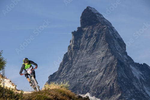 Mountain biker on scenic trail with majestic peak photo