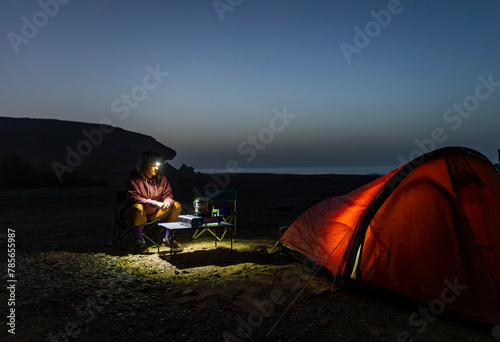 Solo female camper with head torch enjoys night in Fuerteventura photo