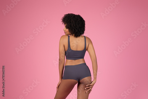 Sporty African American lady posing isolated on pink background