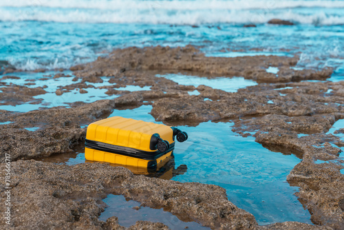 Yellow Suitcase floating in the sea in good weather. Travel insurance and lost luggage concept. © Iryna