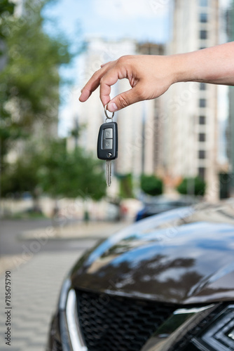 Hand with car keys, man holding key in front of new car © Antonio
