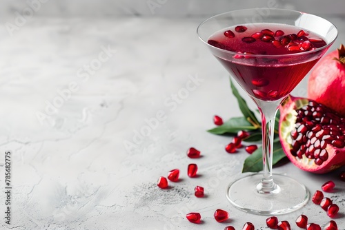 Pomegranate martini cocktail on gray background. Trendy summer drink concept. Refreshing beverage. Design for banner, poster with copy space