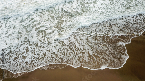 Aerial view of sandy beach and ocean with waves 