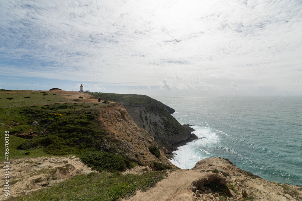 A beautiful view of the ocean with a lighthouse in the distance