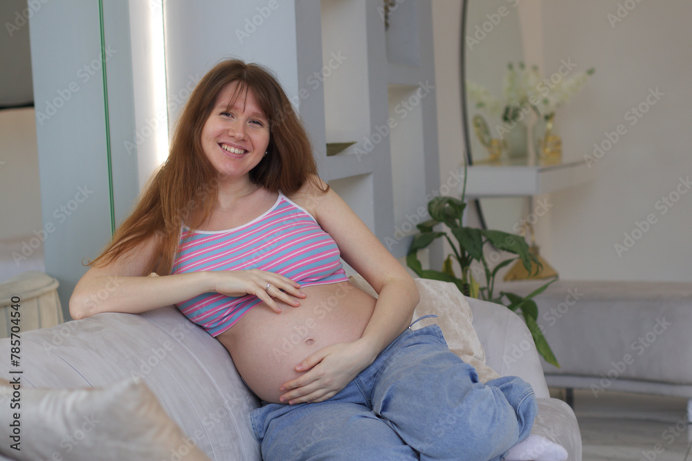 Happy smiling pregnant woman looking camera by touching or feeling tummy - concept of Expecting mother Expecting Baby, Prenatal connection and motherhood. Pregnant Woman Belly. Pregnancy. Baby Shower Happy smiling pregnant woman looking camera by touching or feeling tummy - concept of Expecting mother Expecting Baby, Prenatal connection and motherhood. Pregnant Woman Belly. Pregnancy. Baby Shower