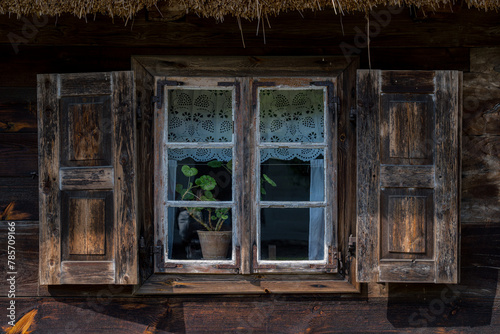 drewniane okno w starej drewnianej chłopskiej chacie na wsi