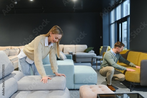 Couple choosing sofa and pillows at furniture store
