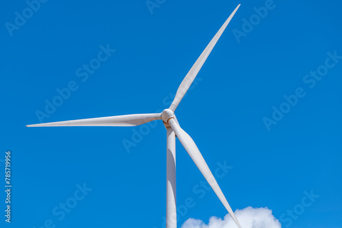 Wind turbine against clear blue sky photo