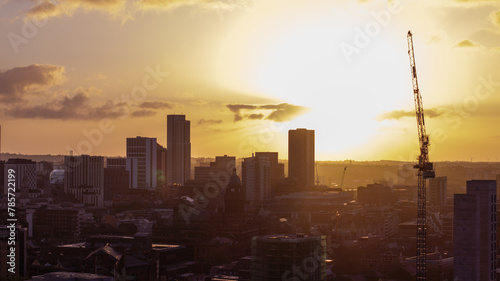 A captivating aerial view captures the golden sunrise over the Leeds city centre, highlighting ongoing construction and the architectural essence of West Yorkshire