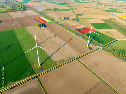 Fields and wind turbines. A wind generator on the  field. View from drone. Green energy production. Landscape from air at the day time. Photo for wallpaper and background. © biletskiyevgeniy.com