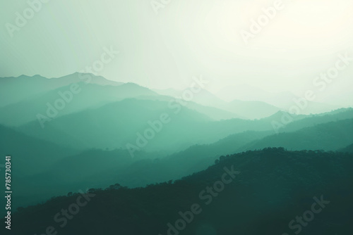 Layered Mountain Silhouettes with Mist Creating an Ethereal Green Landscape