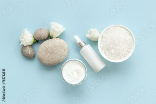 Layout of white cosmetics products and roses flowers, top view