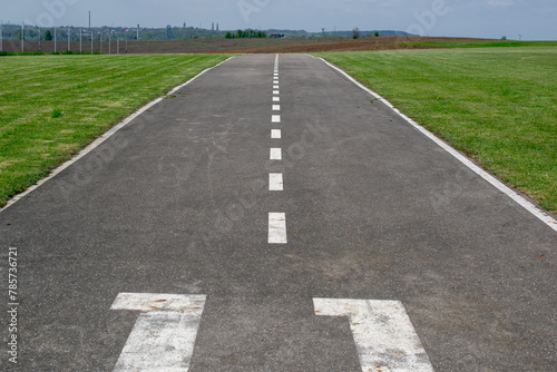 empty airport runway, asphalt with white lines © Remigiusz