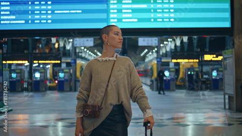 Stylish girl waiting train arrival at modern urban station close up zoom in.
