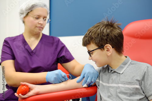 A nurse takes blood from a child using butterfly needle. Close up view during of taking a blood sample for examination in a modern laboratory or hospital.
