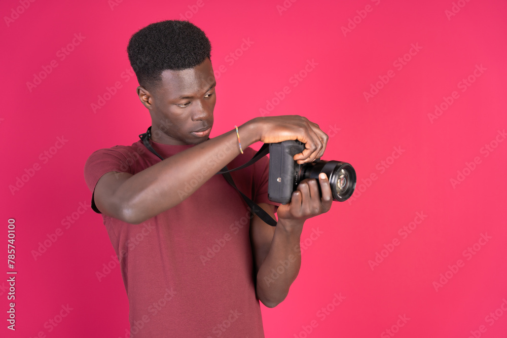 Man Holding Camera Against Pink Background