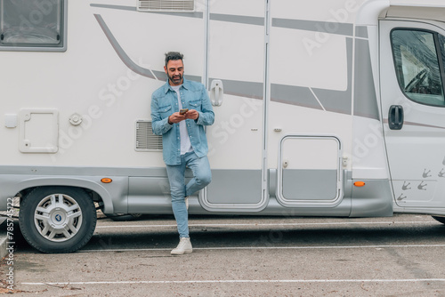 attractive traveler man with caravan and mobile phone