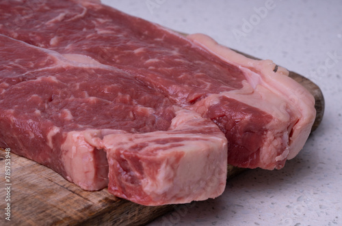 Pair of Raw Sirloin Steaks Closeup on a Chopping Board