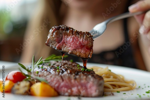 High-definition close-up of a woman enjoying a forkful of tender, succulent steak