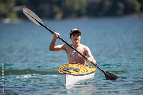 Young man enjoying kayaking during his summer vacation in the lakes of southern Argentina, San Carlos de Bariloche, Patagonia.