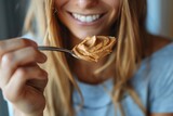 Macro shot of a woman savoring a spoonful of creamy peanut butter