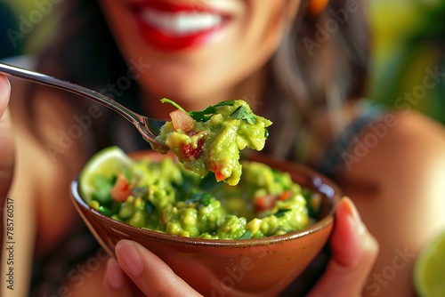 High-definition close-up of a woman enjoying a spoonful of zesty guacamole photo