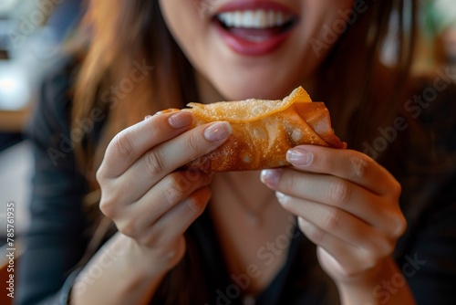 Detailed close-up of a woman munching on a crispy  golden spring roll