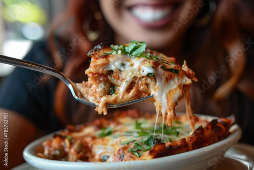 Detailed close-up of a woman relishing a forkful of savory lasagna photo