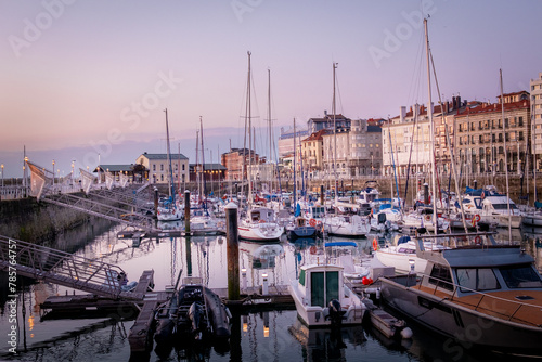 Twilight tranquility, Gijón port, calm waters, city skyline, serene ambiance, peaceful boats.